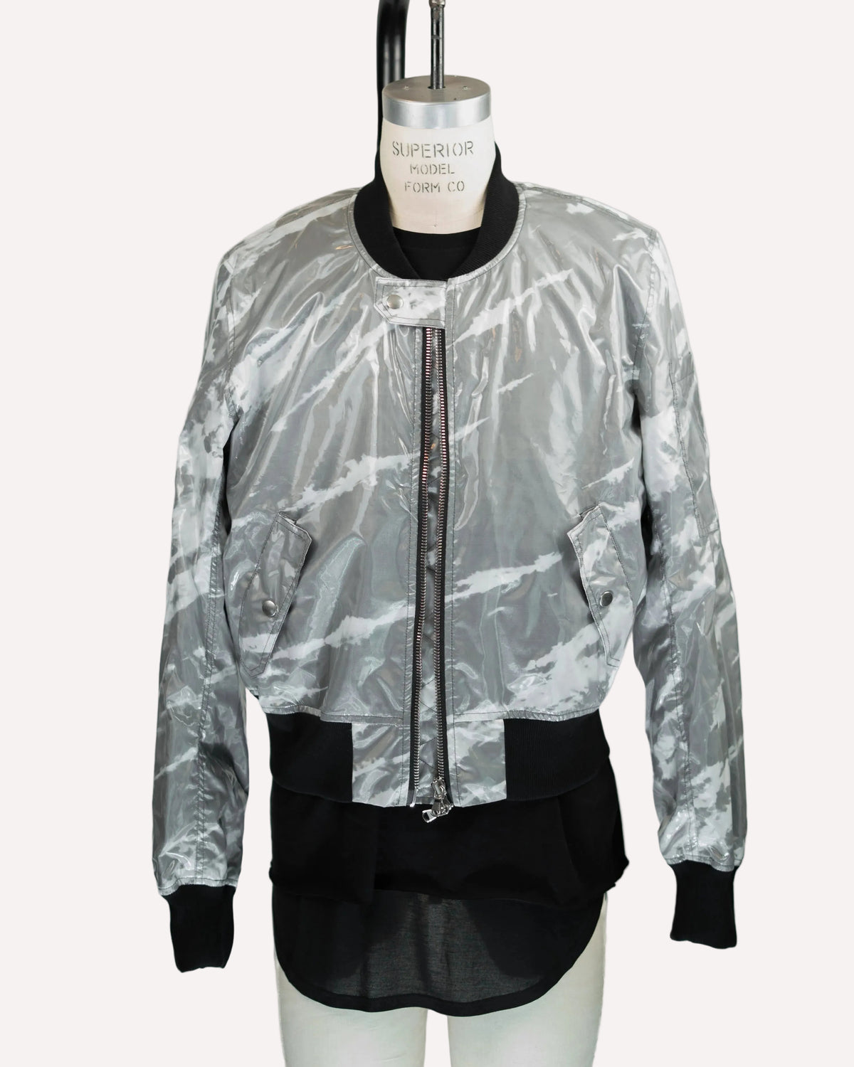 A silver and black marbled JKEEFER bomber jacket displayed on a mannequin torso against a plain white background.