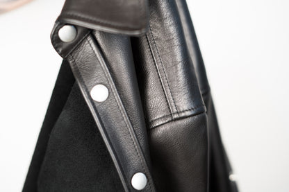 a close up detail shot of a JKEEFER leather shirt, showing the leather grain and heavy duty snaps 