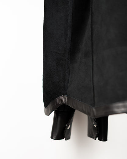 Close-up of a black JKEEFER leather shirt with interior suede  showing hanging against a plain white background.